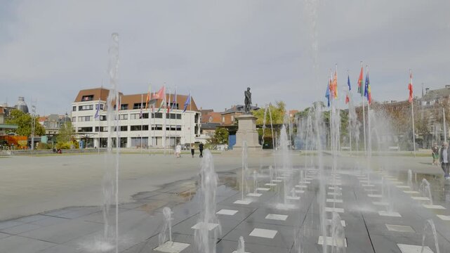Static view, Place Rapp in Colmar, Alsace, France, showing fountain jets, the historic General Rapp monument and international flags in the central public square