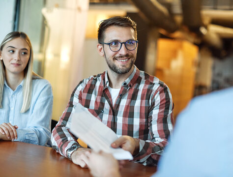 Two of young businessman having a meeting and looking at a document or a contract agreement in the office. Teamwork and success concept