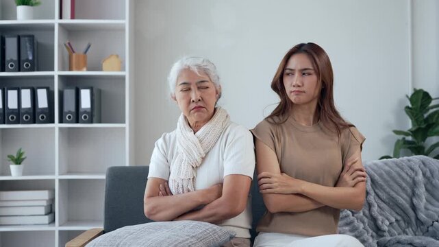 Frustrated mother and daughter ignoring each other after argument showing family conflict and generation gap