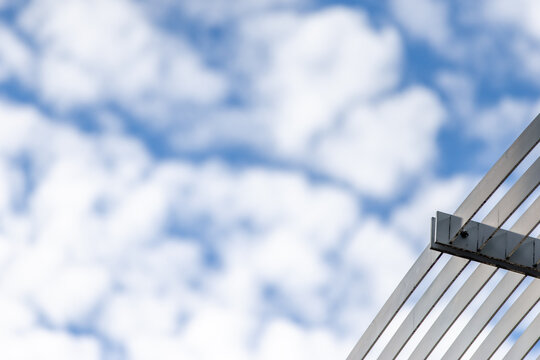 Modern Architectural Steel Beams Against Blurred Blue Sky and Clouds, Background Texture