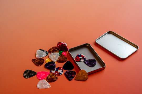 detail shot of a collection of Colorful guitar plectrums picks on a table.