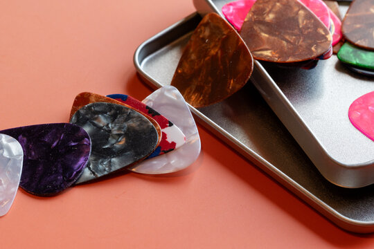 detail shot of a collection of Colorful guitar plectrums picks on a table.