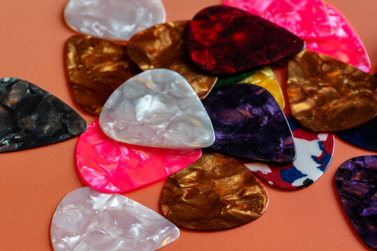 detail shot of a collection of Colorful guitar plectrums picks on a table.