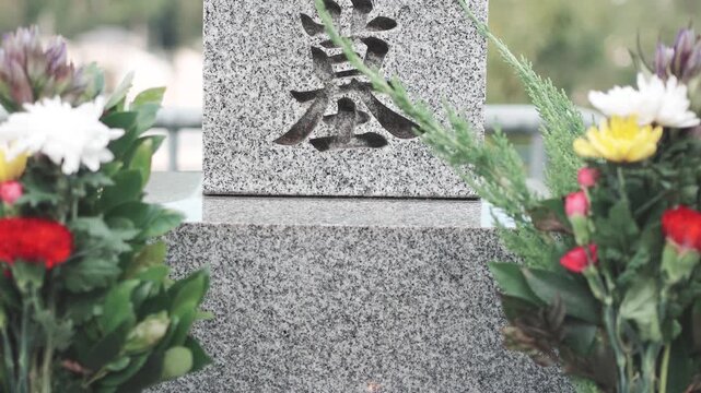 Incense Smoke Rising at Japanese Grave with Flowers