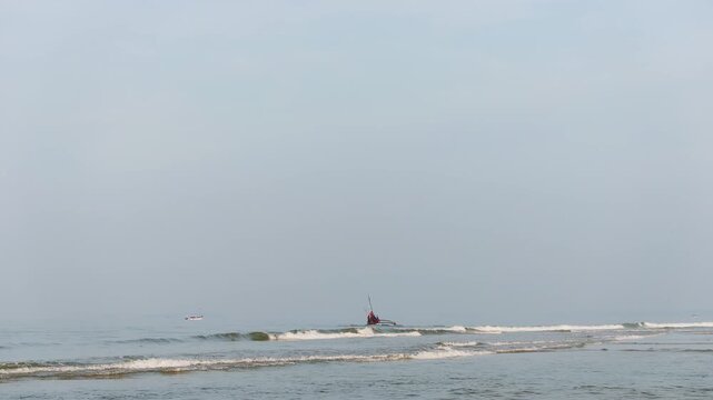 Mandrem beach landscape with traditional fishing boat calm ocean