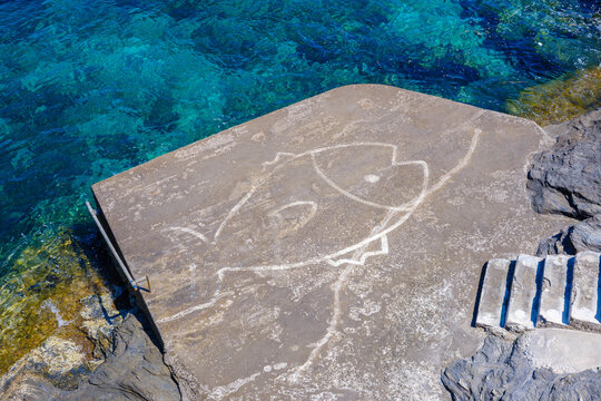 Rock surface with carved fish, Andros, Greece