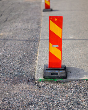 Red and yellow roadwork bollard marking temporary construction zone.