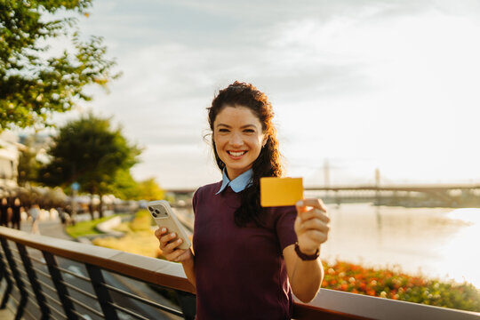 Woman holding credit card and phone for online shopping