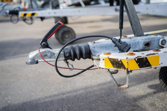 Trailer coupling with latch handle, rubber bellows and electrical connector on a braced drawbar, showing towing connection components for trailer operation and servicing