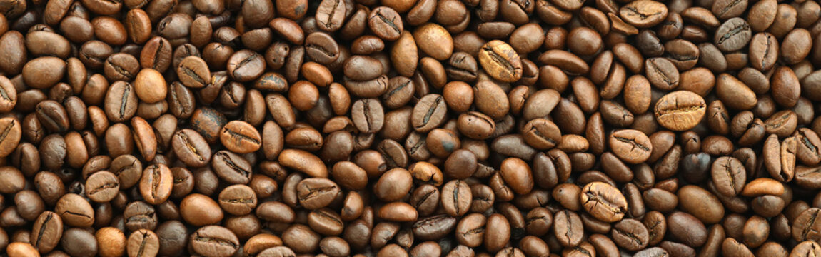 Detailed view on brown roasted coffee beans in big pile on table close up