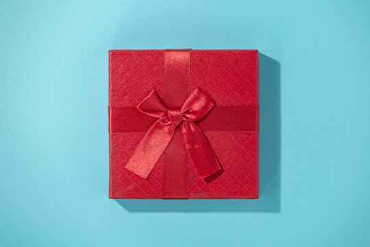 flat lay photo of red gift box on blue background