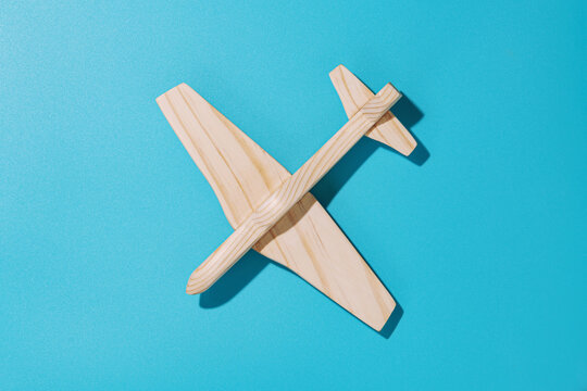 Wood airplane on blue background, top view