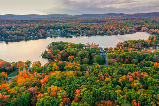 Kemah Lake in Hampton Township, Sussex County, NJ, surrounded by brilliant fall foliage at dusk aerial drone