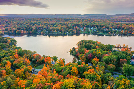 Kemah Lake in Hampton Township, Sussex County, NJ, surrounded by brilliant fall foliage at dusk aerial drone
