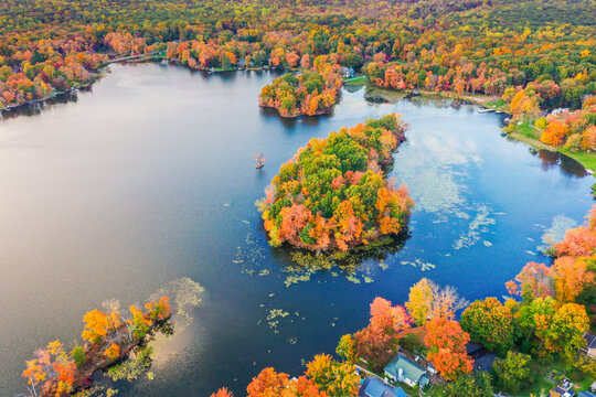 Kemah Lake in Hampton Township, Sussex County, NJ, surrounded by brilliant fall foliage at dusk aerial drone