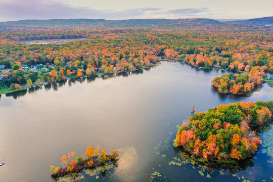 Kemah Lake in Hampton Township, Sussex County, NJ, surrounded by brilliant fall foliage at dusk aerial drone