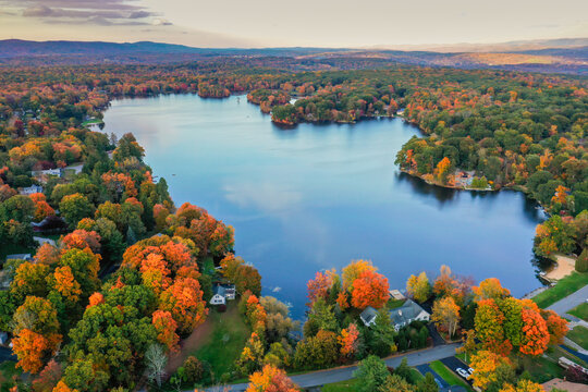 Kemah Lake in Hampton Township, Sussex County, NJ, surrounded by brilliant fall foliage at dusk aerial drone