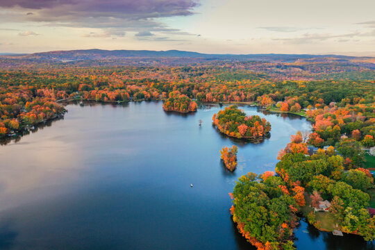 Kemah Lake in Hampton Township, Sussex County, NJ, surrounded by brilliant fall foliage at dusk aerial drone