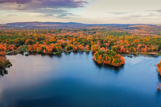Kemah Lake in Hampton Township, Sussex County, NJ, surrounded by brilliant fall foliage at dusk aerial drone