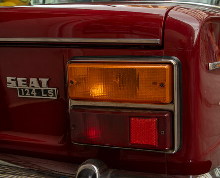 GANDIA, SPAIN - OCTOBER 4, 2026: Rear taillight and emblem badge of a vintage red SEAT 124 LS classic sedan car.