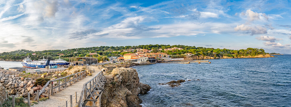 Hy&egrave;res, France - September 20, 2026: A coastal view of the Tour Fondue harbor in the evening sun, with Mediterranean-style houses, a rocky coastline and calm sea.