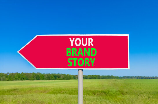 Branding and your brand story symbol. Concept words Your brand story on beautiful red road sign. Beautiful blue sky green grass background. Business branding your brand story concept. Copy space.