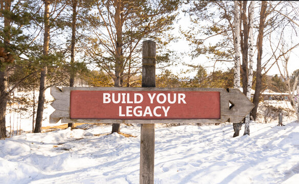 Build your legacy words symbol. Concept words Build your legacy on beautiful road sign. Beautiful winter forest background. Business build your legacy concept. Copy space.