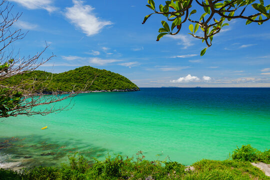 A picturesque beach scene featuring clear turquoise waters gently lapping against the shore