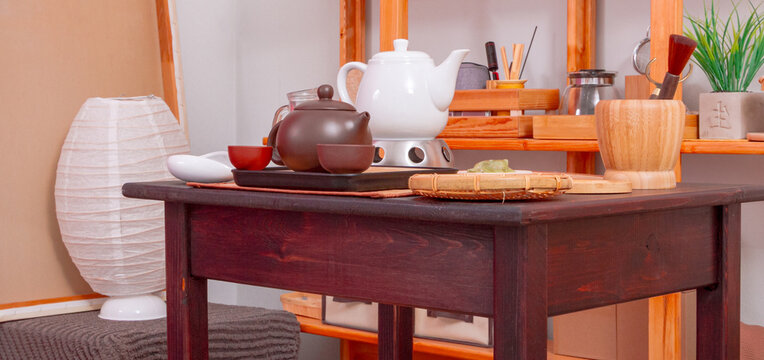 Tea set arranged on wooden table in cozy home tea room. Traditional tea preparation and serving. Asian tea culture, mindful hospitality and relaxation. Interior still life