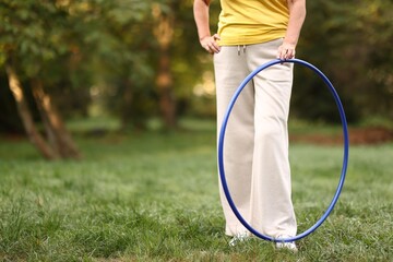 Senior woman with hula hoop in park, closeup. Space for text © New Africa