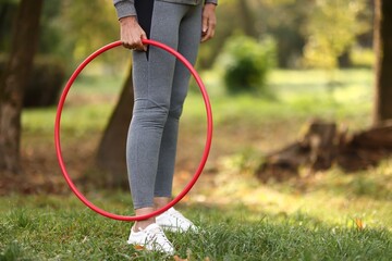 Senior woman with hula hoop in park, closeup. Space for text © New Africa