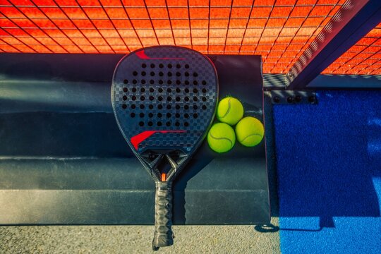 Padel tennis racket with balls. Background with copy space. Sport court and balls. Download a high quality photo with paddle for the design of a sports app or social media advertisement