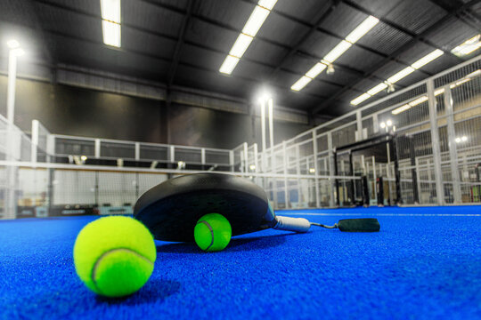 Padel tennis racket with ball. Background with copy space. Sport court and ball. Download a high quality photo with paddle for the design of a sports app or social media advertisement