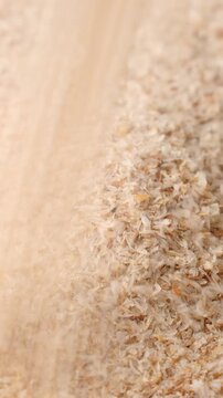 Psyllium husk (Ispaghula) falling down close up. Dietary fiber product, vertical video