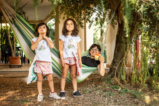 Funny Back-to-School Scene with Two Girls Ready for Kindergarten and Mom Relaxing in a Hammock