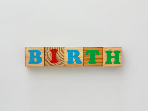Wooden blocks spelling the word BIRTH in colorful letters