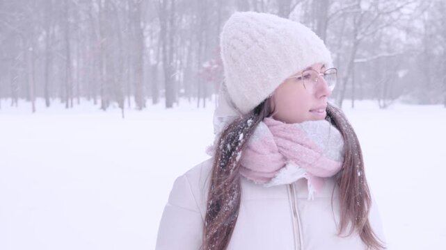 Woman winter portrait. Young female enjoying snowy outdoors. Calm lifestyle concept.