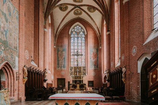 Gothic interior of Toruń Cathedral with altar and stained glass