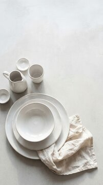 Minimalist White Ceramic Tableware Stacked on a Neutral Surface.