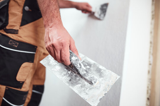 House painter putting skim coat and working on a home renovation.