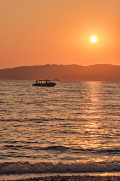 Barca a motore e riflessi del sole al tramonto a Skopelos