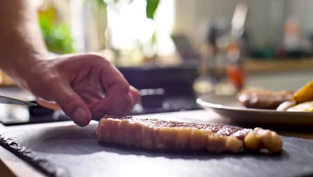 4K Video of meat preparation on a wooden cutting board, showing careful slicing and fresh ingredients in a kitchen setting.