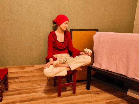 A woman sits at home holding a piggy bank. Concepts of saving money and personal finance. Relaxation and mindful living