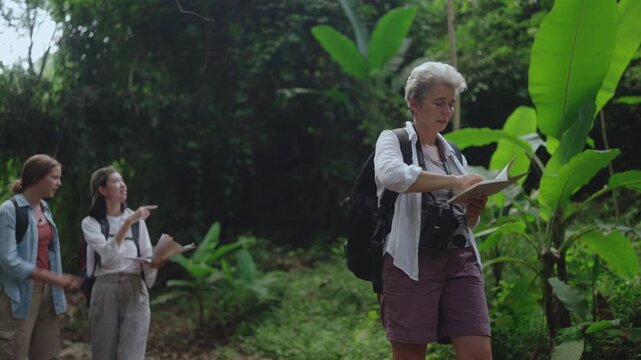 Hiking Explorer Botanist Woman Senior Group Trekking Forest Ecology Expedition Researching Tropical Plants, Taking Notes, Recording Observations, and Sharing Knowledge in Lush Natural Habitat