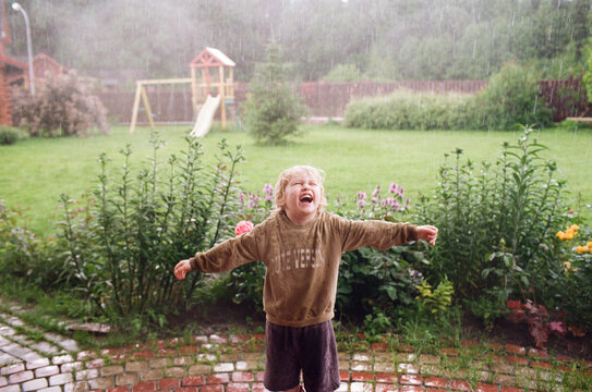 A little boy is happy about the summer rain