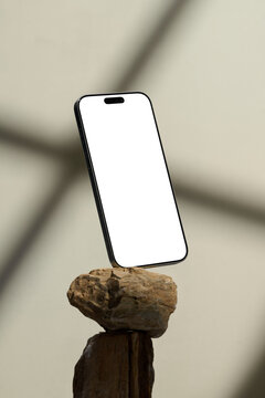 Smartphone with blank screen balanced on a rock