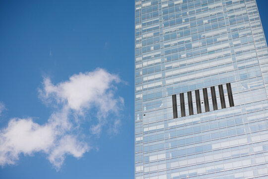 Glass Skyscraper Against Blue Sky and Clouds