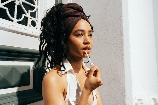 Woman Applying Lip Gloss Outdoors