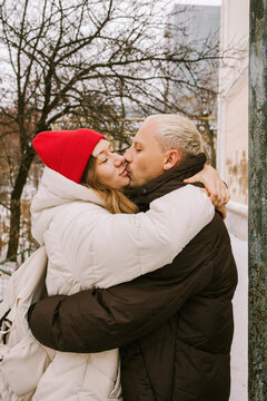A couple kisses while embracing.