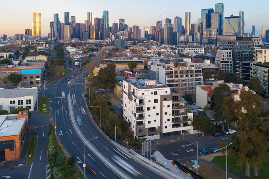 Speeding traffic on a arterial road leading into a city skyline